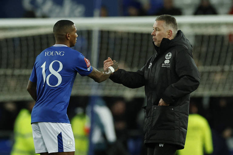 Darren Ferguson， treinador do Peterborough， cumprimenta o jogador Ashley Young， do Everton， que usa camisa com o número 18 às costas， depois de partida entre os times no estádio Goodison Park， em Liverpool， pela Copa da Inglaterra