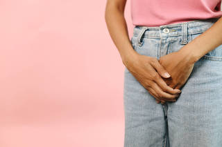 Woman Feeling Pain In Uterus Area Hands Holding Crotch Lower Abdomen Isolated On Pink Background. Cervical Cancer Awareness.