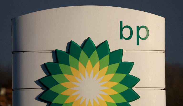 A imagem mostra um sinal da BP， com o logotipo da empresa em verde e amarelo. O logotipo é composto por uma flor estilizada com pétalas verdes e amarelas， e o texto 039;bp039; está escrito em verde na parte superior direita do sinal.