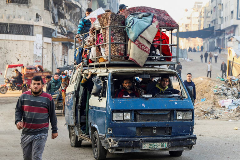 Vários carros carregados com pertences domésticos percorriam uma via repleta de escombros e detritos na Cidade de Gaza; palestinos tinham esperança de que guerra seria encerrada