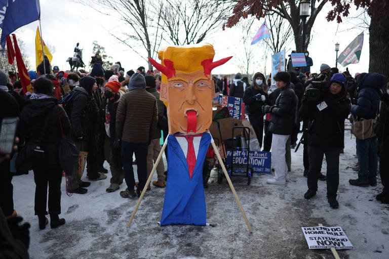 Manifestantes contra o presidente eleito dos EUA, Donald Trump, exibem um recorte de papelão dele com feições diabólicas no Meridian Hill Park no dia da posse do segundo mandato presidencial de Donald Trump em Washington, EUA
