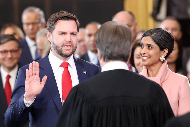 O vice-presidente eleito dos EUA, J.D. Vance, faz o juramento enquanto sua esposa, Usha Vance, sorri
