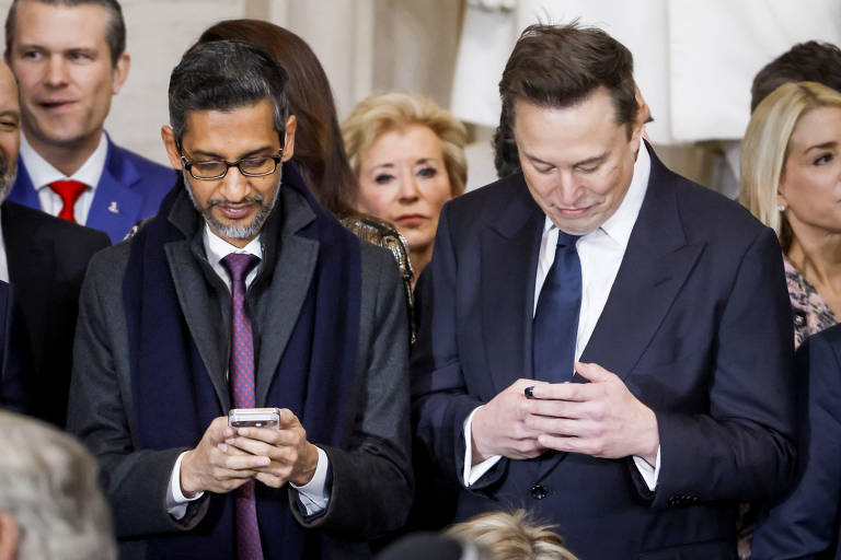 Sundar Pichai, CEO do Google, e Elon Musk, dono da Tesla, do SpaceX e do X, mexem no celular antes de cerimônia de posse de Donald Trump, no Capitólio, em Washington