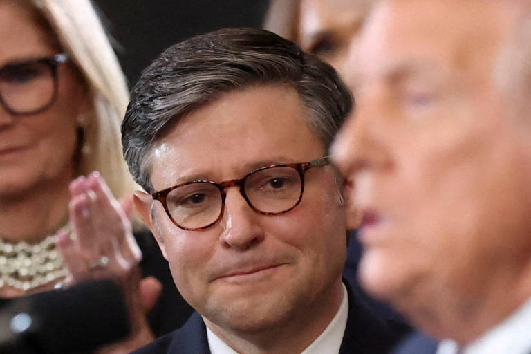 O presidente da Câmara, Mike Johnson, observa enquanto Trump se dirige aos convidados na posse em Washington, EUA