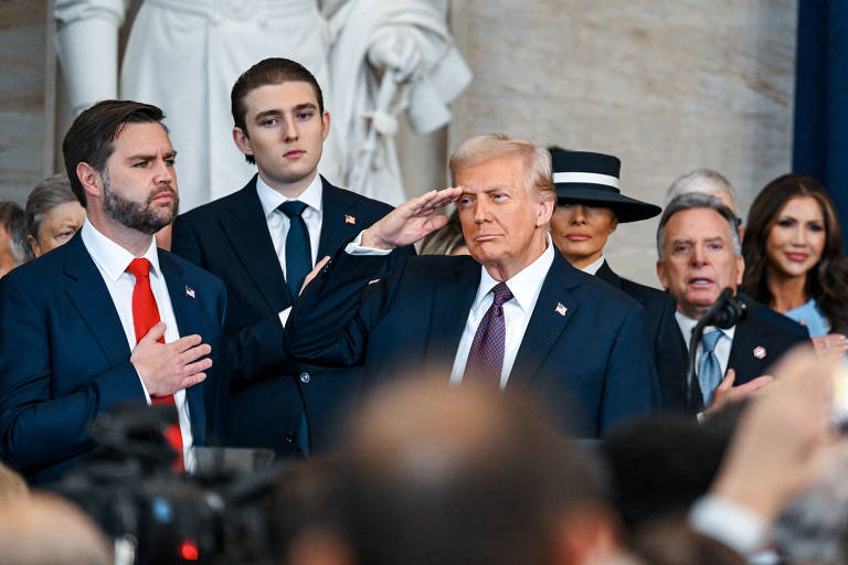 Donald Trump bate continência observado pelo vice J.D. Vance, durante cerimônia de posse em Washington