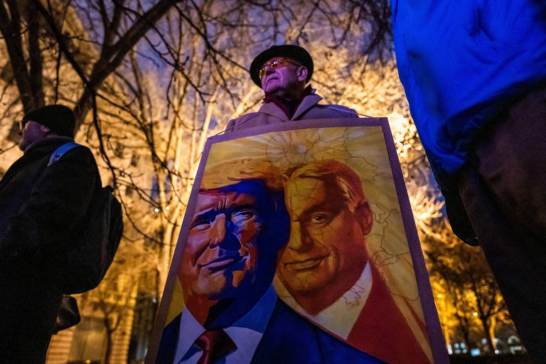 Apoiador usa placa com o primeiro-ministro húngaro, Viktor Orbán, e o presidente dos EUA, Donald Trump, em Budapeste, do lado de fora da embaixada americana, enquanto a posse acontecia no Capitólio