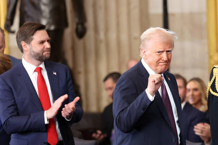Donald Trump celebra após tomar posse, enquanto J.D. Vance aplaude no Capitólio dos EUA, em Washington