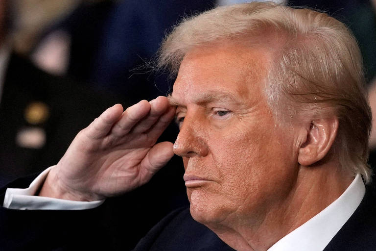 Trump com mão na cabeça， em gesto de continência (como um militar)