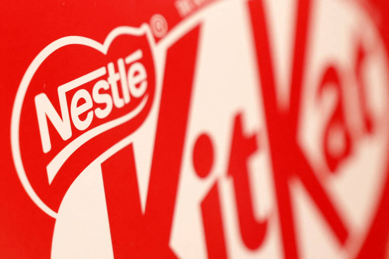 A imagem mostra uma parte da embalagem do chocolate Kit Kat， com o logotipo da Nestlé em destaque. O fundo é vermelho e o logotipo é branco， com a palavra 039;Kit Kat039; em letras grandes e estilizadas.