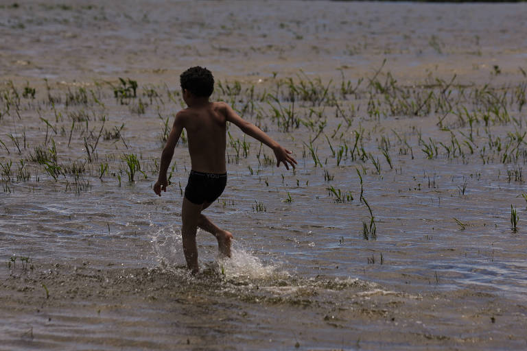 Criança correndo em praia da represa do Guarapiranga， localizada no extremo da zona sul de São Paulo