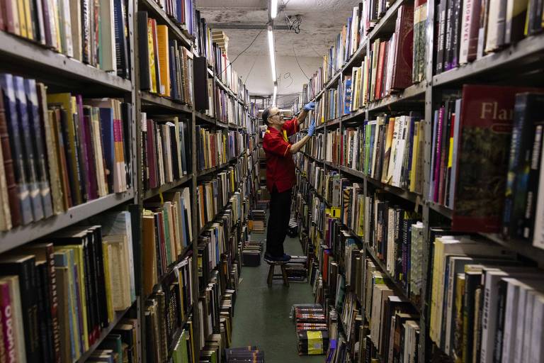 Stênio Alencar, arquivista de 83 anos, organiza o estoque da loja há 25 anos