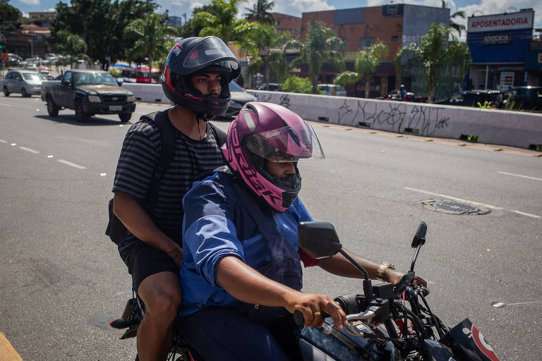 Motociclista e passageiro em fente à estação Capão Redondo de metrô, na zona sul da capital; condutores relatam remuneração mais vantajosa e alta demanda pelas viagens