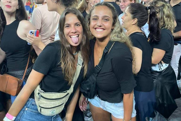 Foto mostra duas jovens brancas e loiras durante um show