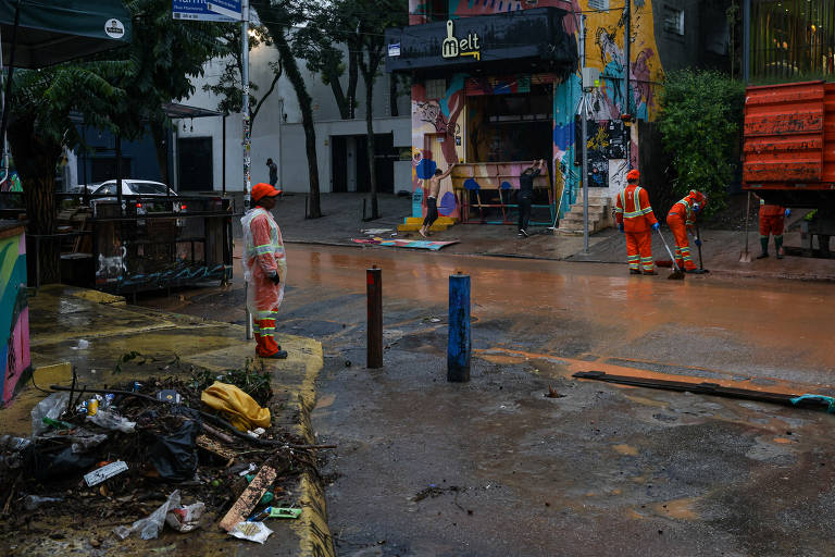 Funcionários da limpeza urbana em ação logo após o fim da enchente na Vila Madalena