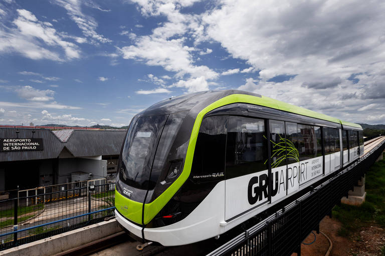 Trem nas cores verde， preto e branco， com a inscrição GRU， visto pela lateral a partir da frente