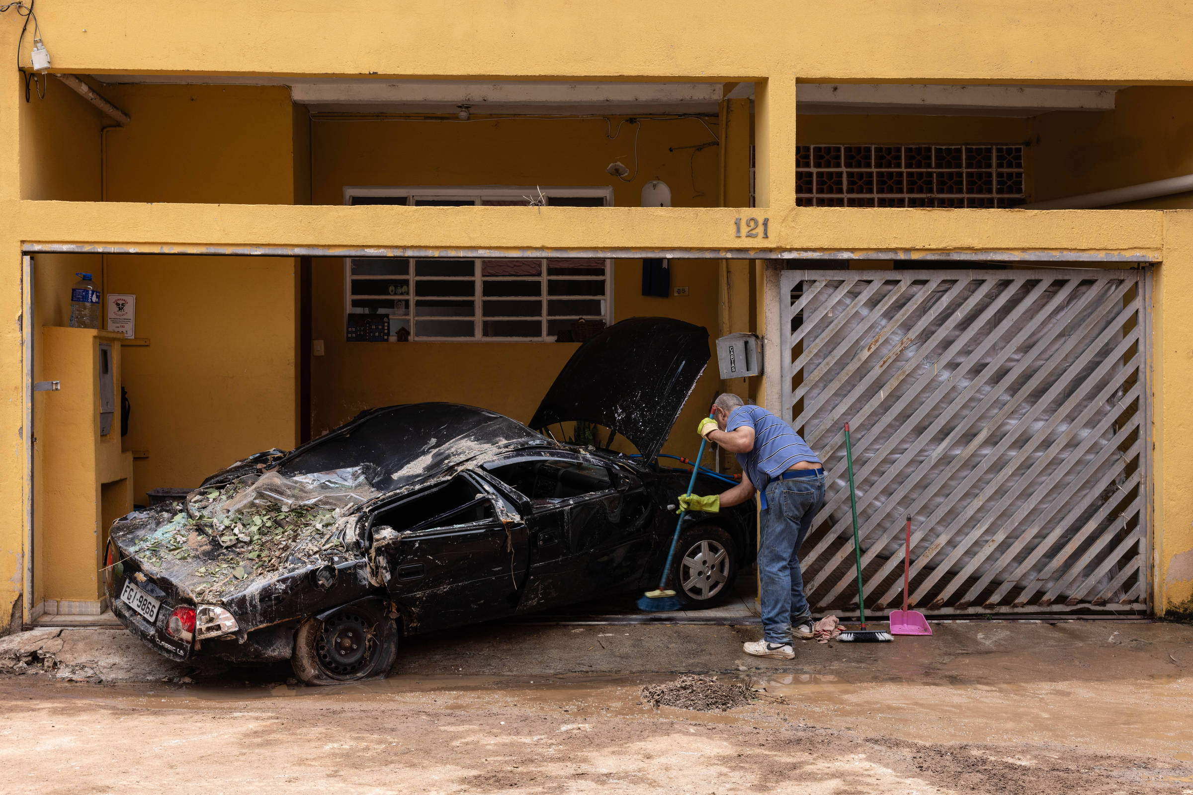 Moradores da Vila Madalena esperam por próximo alagamento enquanto limpam suas casas