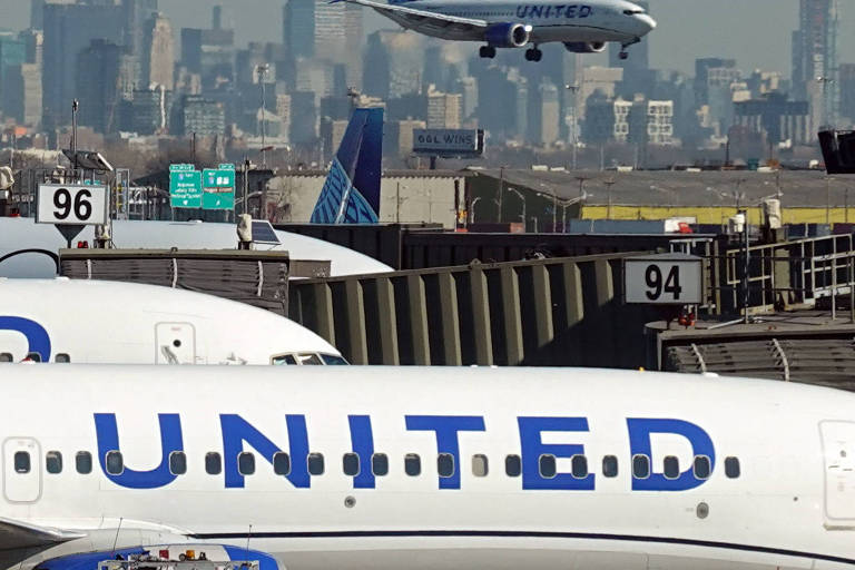 Imagem mostra um avião se aproximando da pista de pouso， enquanto outros aviões estão estacionados