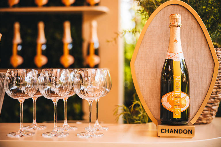 A foto mostra uma garrafa de Chandon com taças balão ao lado