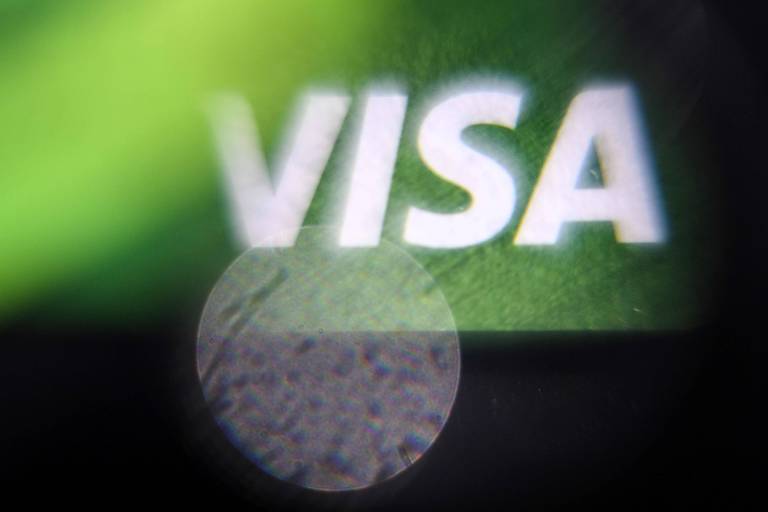 A imagem mostra uma parte do logotipo da Visa em foco， com a palavra 039;VISA039; em letras maiúsculas. O fundo é de cor verde， e há uma área desfocada em forma circular na parte inferior da imagem.
