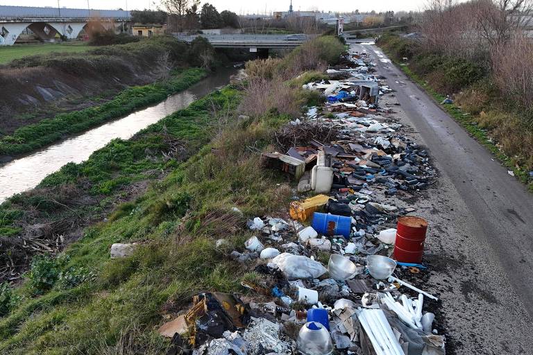 Lixo em uma estrada ao lado de um córrego