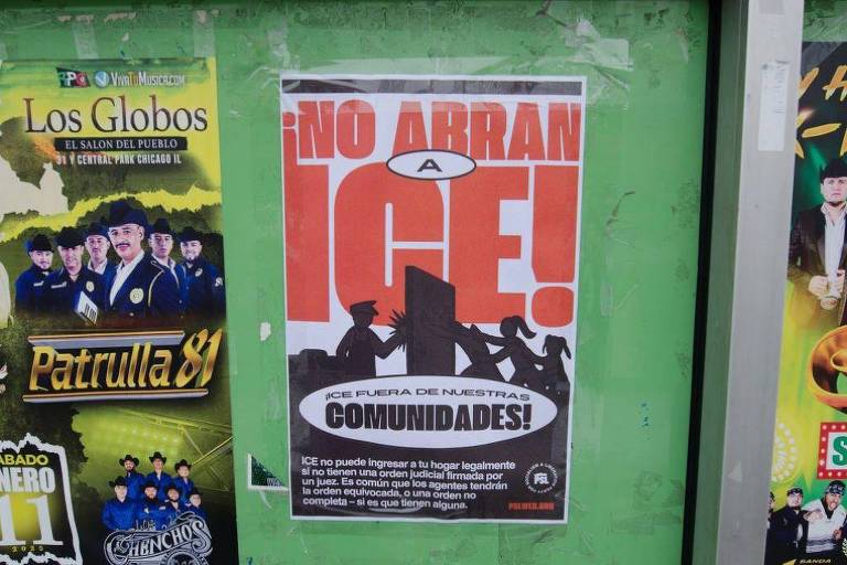 Um cartaz colado em uma parede verde， com o texto em letras grandes e em negrito: 039;¡NO ABRAN A ICE!039; e abaixo， 039;ICE PUERTA DE NUESTRAS COMUNIDADES!039;. O cartaz apresenta silhuetas de pessoas em protesto. Na parte inferior， há uma explicação sobre o ICE e sua relação com as comunidades.