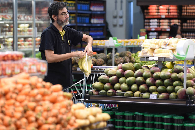 Homem realiza compras em supermercado de Brasília， capital do país