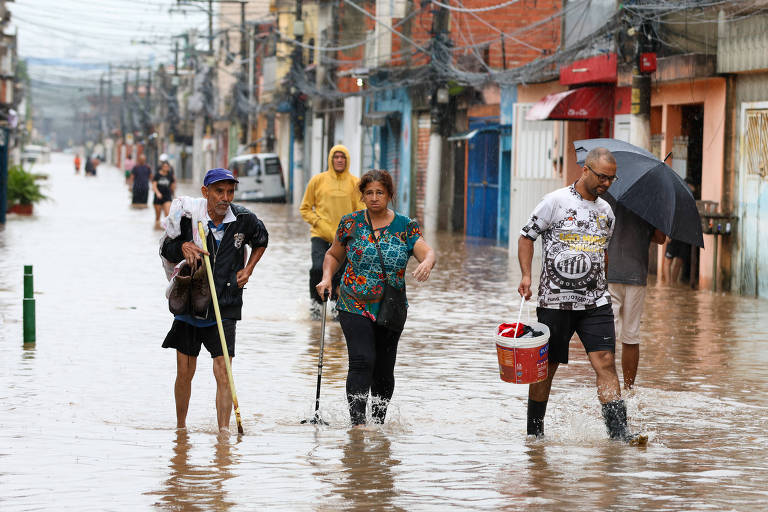 Moradores do Jardim Pantanal caminham em área alagada