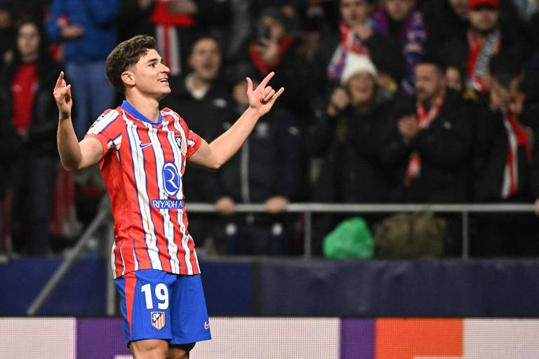 O argentino Julián Álvarez， do Atlético de Madrid， festeja com os braços abertos e sorrindo， em jogo da Champions League contra o Bayer Leverkusen， depois de fazer um gol