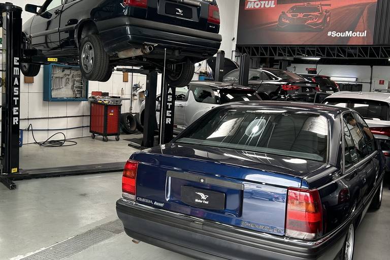 Fiat Tempra no elevador e Chevrolet Omega estacionado na entrada da oficina Motorfast, no Brooklin Novo (zona sul de São Paulo)