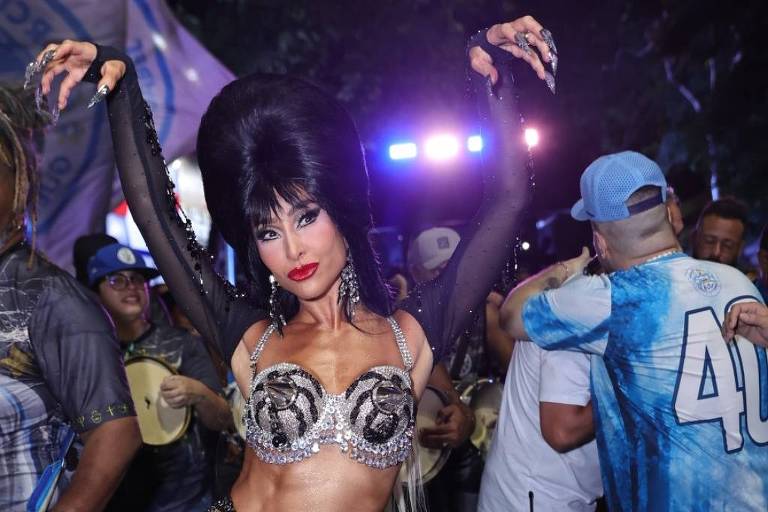 Em foto colorida, mulher veste a fantasia personagem do filme 'Elvira, a rainha das trevas' (1988)