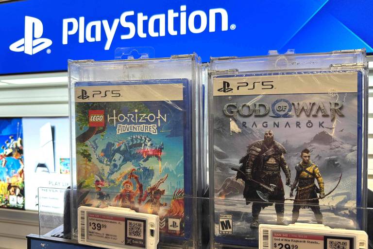 A imagem mostra dois jogos para PlayStation 5 em exibição em uma loja. À esquerda， está o jogo 039;LEGO Horizon039;， e à direita， 039;God of War: Ragnarök039;. Ambos os jogos estão em caixas plásticas transparentes， com etiquetas de preço visíveis na parte inferior. Ao fundo， há um logotipo da PlayStation em destaque.