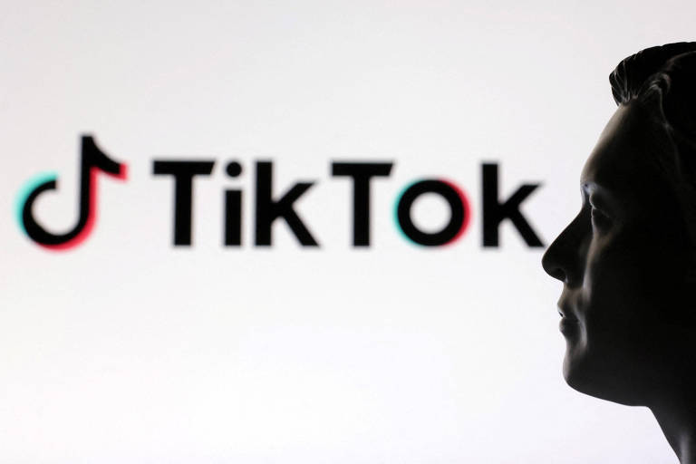 A imagem mostra a silhueta de uma pessoa em perfil， com um fundo claro. Ao fundo， está o logotipo do TikTok， que consiste em um símbolo de nota musical em cores verde e vermelho， acompanhado do nome 039;TikTok039; em letras pretas.