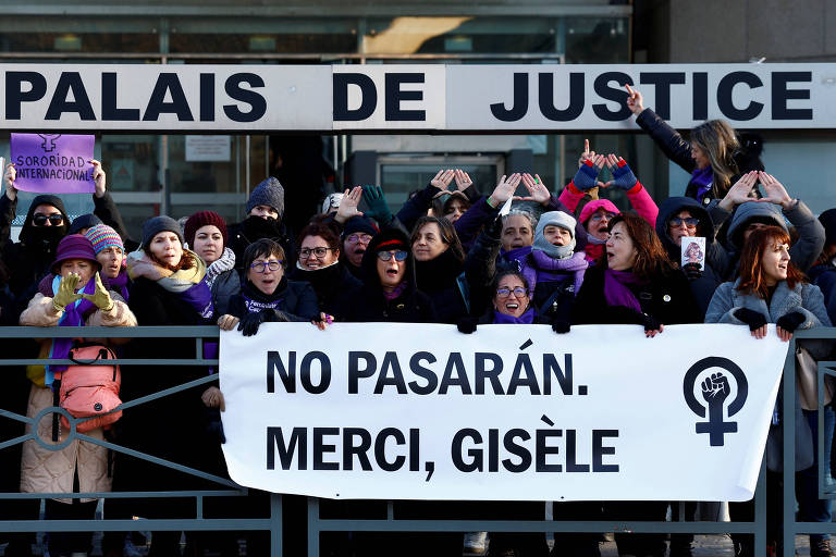 Um grupo de mulheres se reúne em frente ao Palais de Justice， segurando cartazes e uma faixa. A faixa contém a frase 039;NO PASARÁN. MERCI， GISÈLE039;. As participantes estão vestidas com roupas de cores variadas， incluindo tons de roxo， e algumas usam cachecóis e gorros. O ambiente é de protesto e solidariedade.