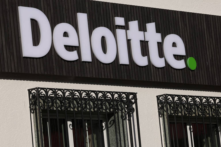 A imagem mostra o logotipo da Deloitte， que é apresentado em letras grandes e brancas sobre um fundo escuro. O logotipo inclui um ponto verde ao final da palavra 039;Deloitte039;. Ao fundo， há uma estrutura com janelas e grades decorativas.