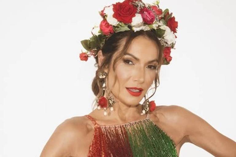 Em foto colorida, mulher posa com fantasia em estúdio
