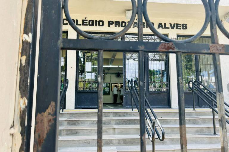 A imagem mostra a fachada do Colégio Profa. Alves， com uma entrada principal visível através de um portão de ferro. O colégio possui escadas que levam à porta de entrada， e o nome da instituição está escrito em letras grandes na parte superior. O ambiente parece bem iluminado e arejado.