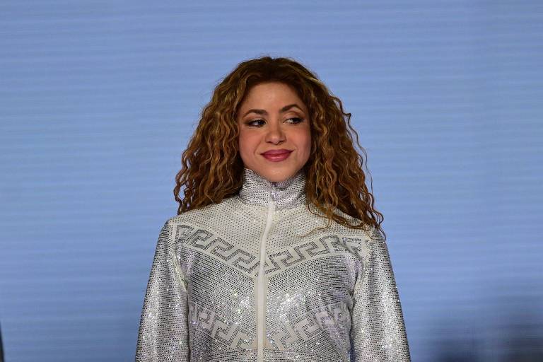 Mulher de branco e cabelos cacheados