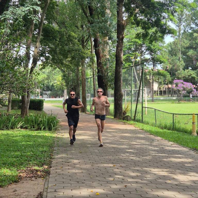 O colunista da Folha Paulo Veira (sem camisa) treina na trilha do clube da USP para prova de biatlo