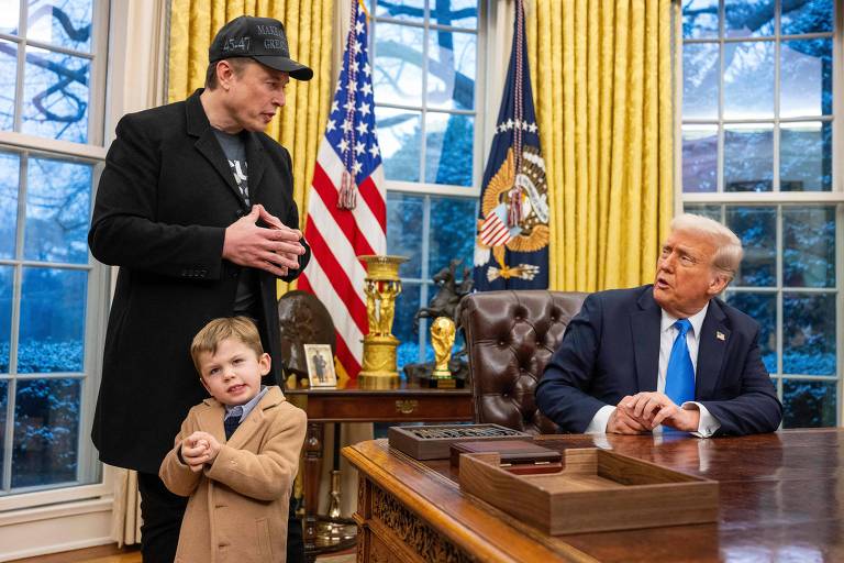 A imagem mostra um homem em pé， usando um boné e uma jaqueta preta， conversando com um homem sentado atrás de uma mesa no Escritório Oval. Ao lado do homem em pé， há uma criança pequena vestindo um paletó claro. O homem sentado parece estar ouvindo atentamente. Ao fundo， há cortinas amarelas e bandeiras dos Estados Unidos