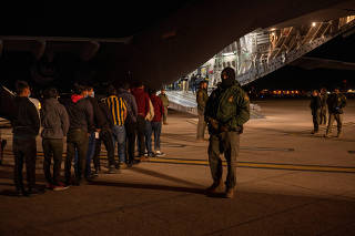 Customs and Border Protection agents load detained migrants onto a C-17 Globemaster III for a removal flight in Tucson