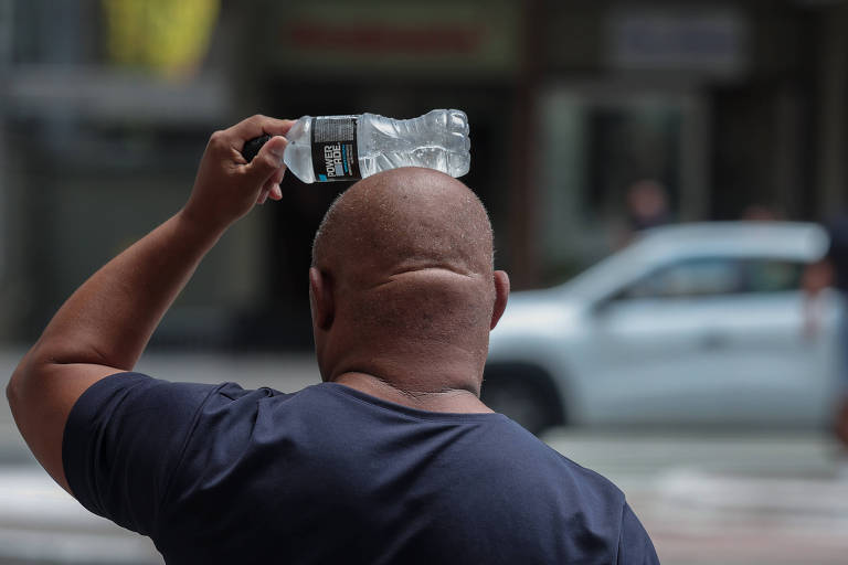 Homem tenta se refrescar com garrafa de água na cabeça， na avenida Paulista. Paulistanos enfrentam mais um dia de forte calor