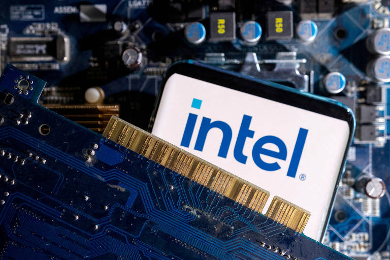 A imagem mostra um processador da Intel posicionado sobre uma placa-mãe. O logotipo da Intel é claramente visível na parte superior do processador， que é branco com letras azuis. A placa-mãe apresenta circuitos e componentes eletrônicos， com detalhes em azul e dourado.