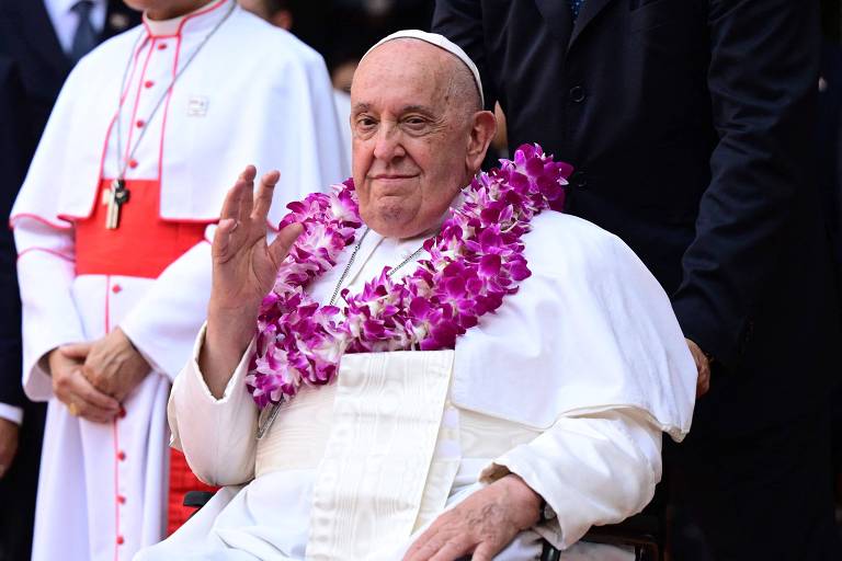 O Papa Francisco usa guirlanda de flores ao chegar para um encontro inter-religioso com jovens em Singapura