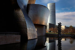 The Iberdrola Tower stands next to the Guggenheim Museum, in Bilbao