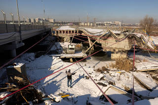 A man looks at the Romanivska Bridge over the Irpin river that was destroyed at the beginning of Russia's war on Ukraine on the day marking the 3rd anniversary of Russia?s invasion, in Irpin