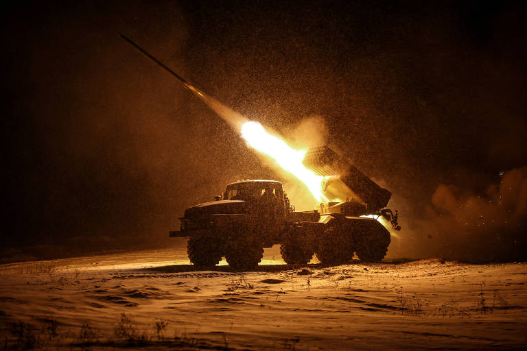 A imagem mostra um veículo militar de grande porte， possivelmente um caminhão， lançando um míssil em um ambiente noturno. A cena é iluminada pela chama e pela fumaça geradas pelo lançamento， enquanto a neve cobre o solo ao redor. O fundo é escuro， destacando a ação do lançamento.