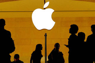 FILE PHOTO: FILE PHOTO: Customers walk past an Apple logo inside of an Apple store at Grand Central Station in New York