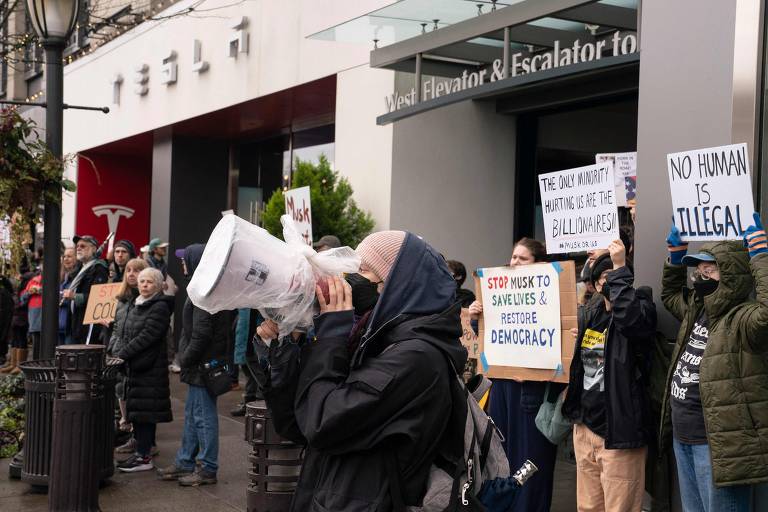 Centenas de pessoas reunidas em frente a uma sede da empresa de Elon Musk em Seattle