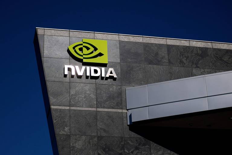 A imagem mostra o logotipo da NVIDIA em um edifício. O logotipo é composto por um símbolo verde que representa um olho estilizado， acompanhado do nome 039;NVIDIA039; em letras brancas. O fundo é de uma parede de pedra escura sob um céu azul claro.