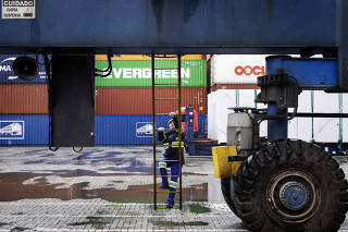 Operadores manuais de guindastes no Porto de Santos estao sendo treinados para operar  mesmos guindastes de forma remota: Sob chuva, operadora Erica Pereira Matias, 40, inicia subida em guintaste - no terminal da empresa Santos Brasil - onde opera no modo manual
